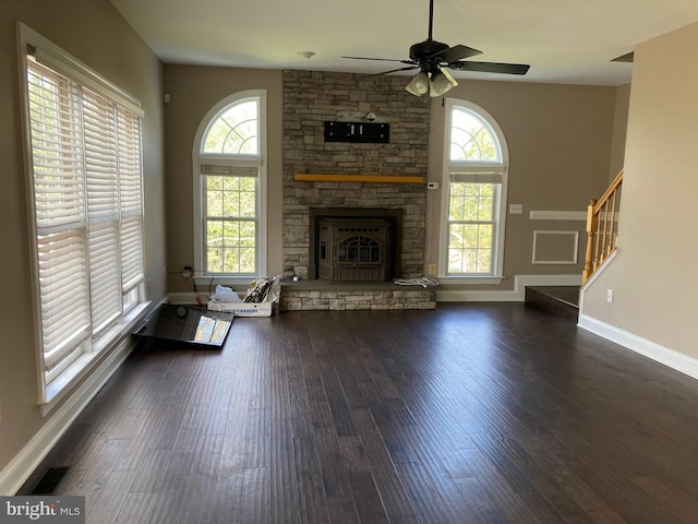 unfurnished living room with visible vents, baseboards, ceiling fan, a fireplace, and dark wood-style floors