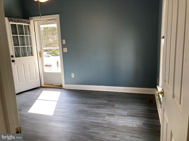 entryway with baseboards and wood finished floors