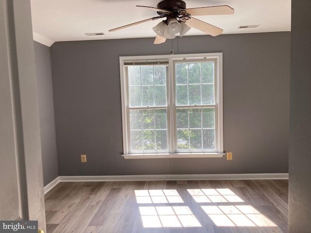 unfurnished room featuring visible vents, baseboards, a ceiling fan, and wood finished floors