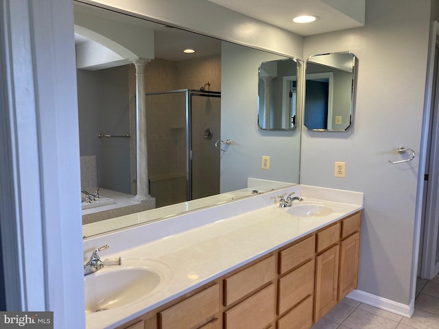 full bath featuring a sink, tile patterned floors, decorative columns, and a stall shower