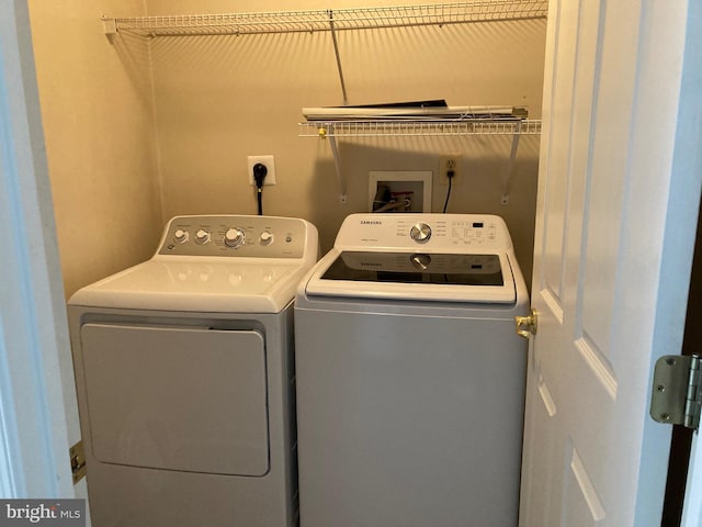 clothes washing area with separate washer and dryer and laundry area