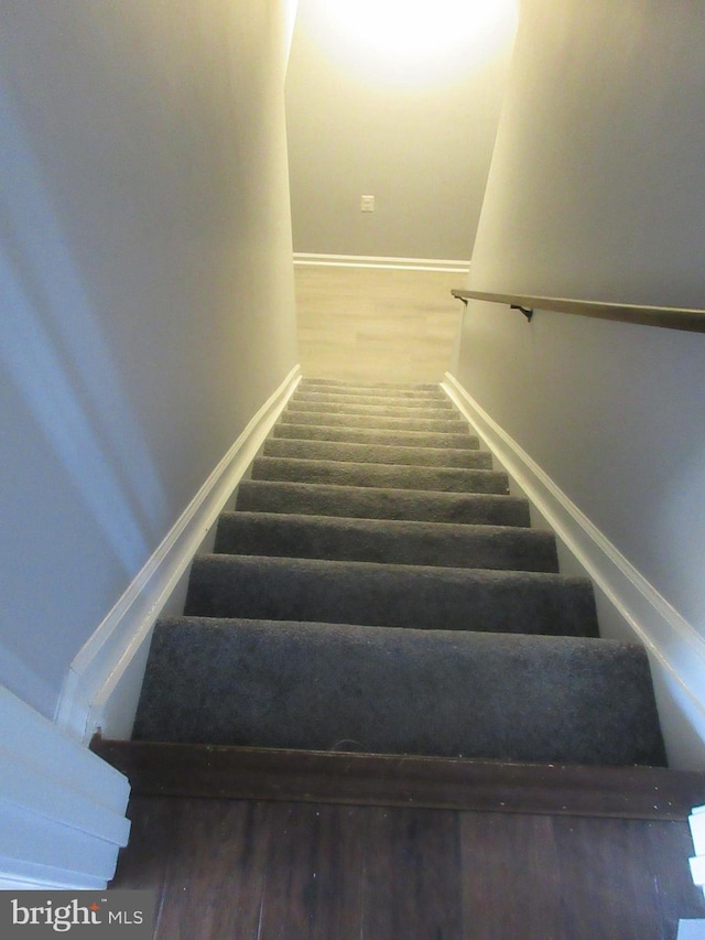 stairs with baseboards and wood finished floors