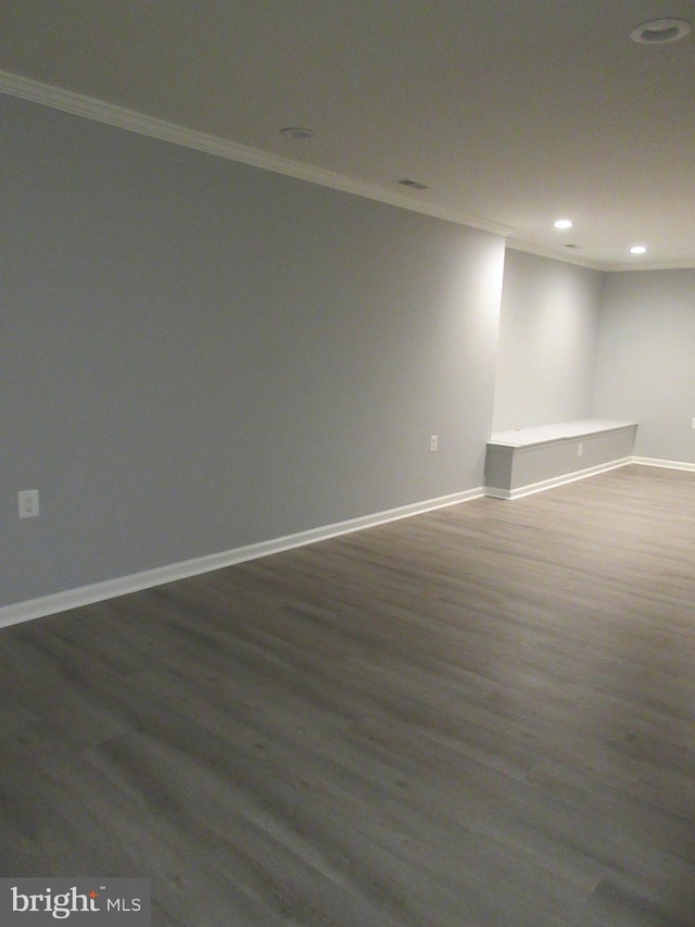 basement featuring crown molding, baseboards, recessed lighting, and dark wood-style floors
