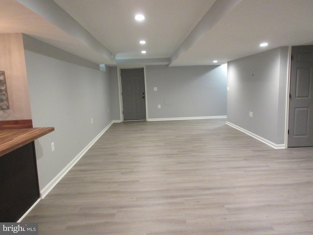 finished below grade area with wood finished floors, baseboards, and recessed lighting