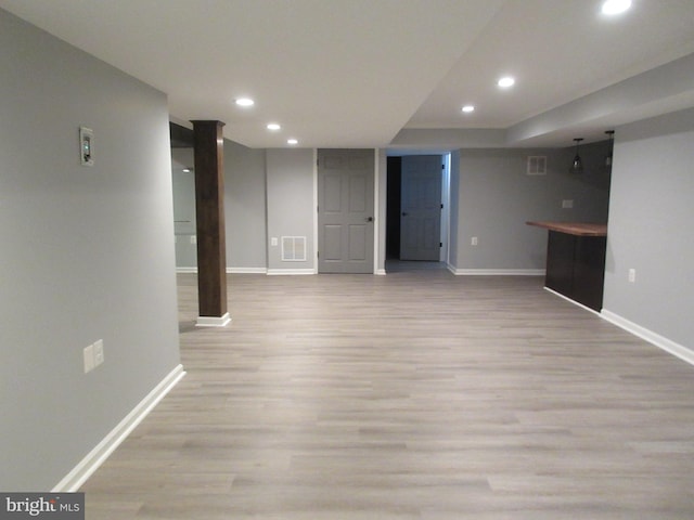 finished basement with wood finished floors, baseboards, visible vents, and recessed lighting