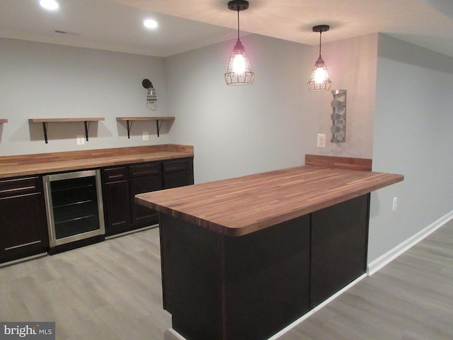 bar featuring pendant lighting, light wood-style floors, recessed lighting, wine cooler, and baseboards