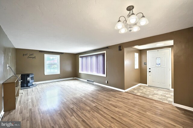 14 Longview Rd, Seven Valleys, PA 17360 - unfurnished living room with baseboards, a wood stove, a chandelier, and wood finished floors