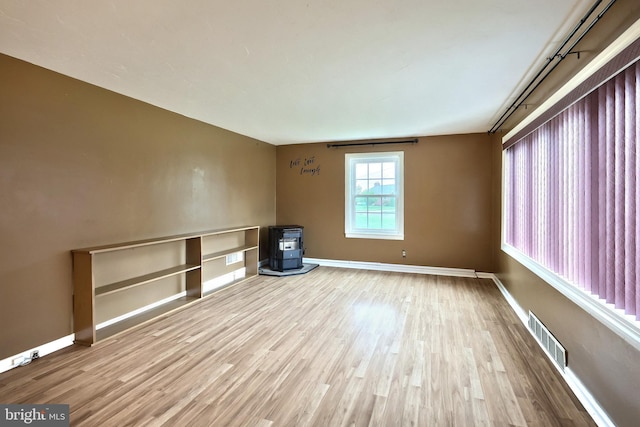 14 Longview Rd, Seven Valleys, PA 17360 - unfurnished room featuring a wood stove, visible vents, wood finished floors, and baseboards