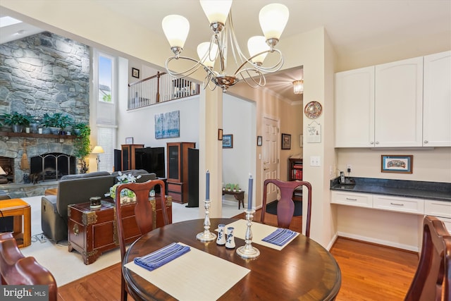 7906 Plum Creek Dr, Gaithersburg, MD 20879 - dining area featuring light wood-style floors, a chandelier, and a fireplace