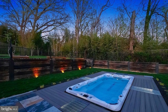 view of pool featuring a fenced backyard and hot tub deck surround