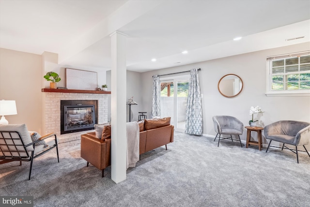 carpeted living area with baseboards, a brick fireplace, and recessed lighting
