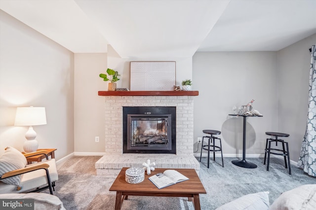 living room featuring baseboards, carpet, and a fireplace