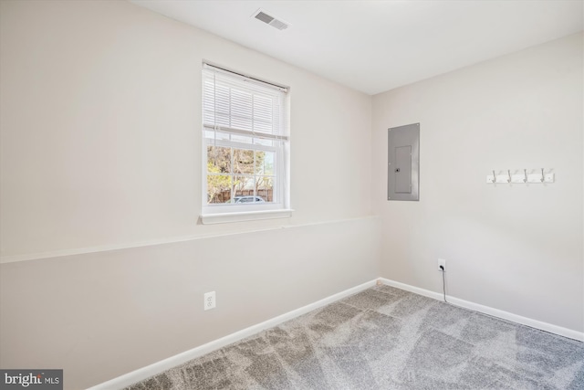 carpeted empty room featuring visible vents, baseboards, and electric panel