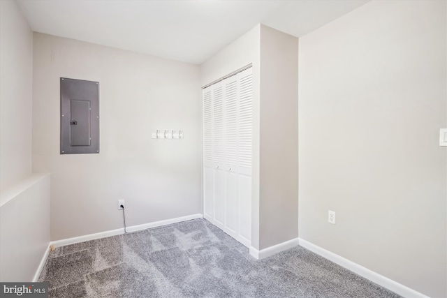 unfurnished bedroom featuring electric panel, a closet, baseboards, and carpet floors