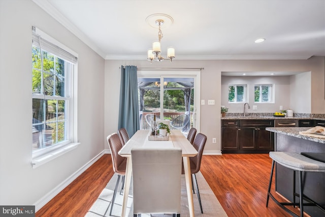 dining area with a wealth of natural light, a chandelier, and wood finished floors