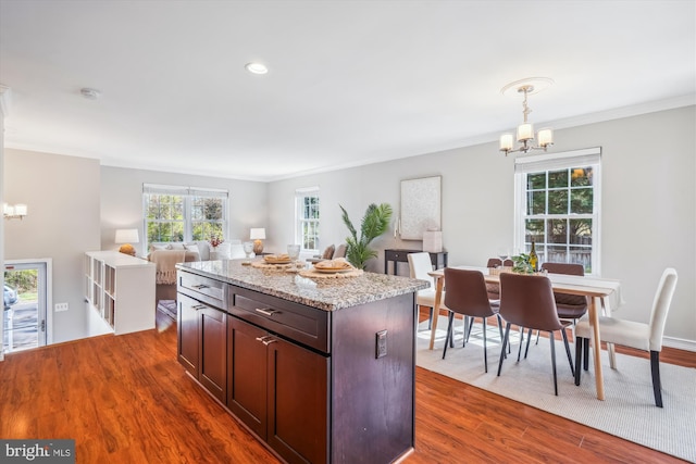 kitchen with crown molding, a notable chandelier, and dark wood finished floors
