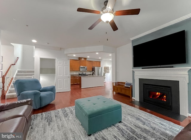 living area with recessed lighting, stairway, a ceiling fan, a fireplace with flush hearth, and wood finished floors