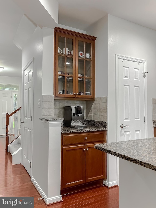 bar with tasteful backsplash, dark wood-style flooring, and baseboards
