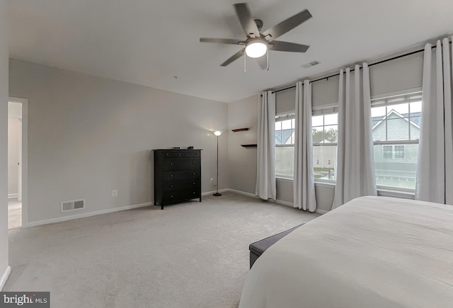 bedroom with light carpet, visible vents, baseboards, and a ceiling fan