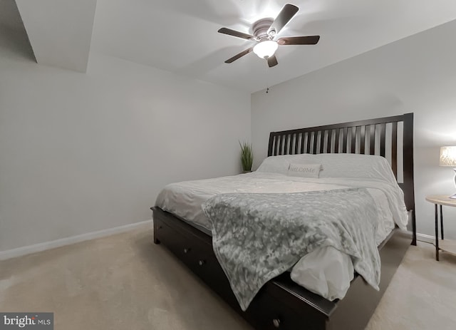 bedroom featuring light colored carpet, baseboards, and a ceiling fan