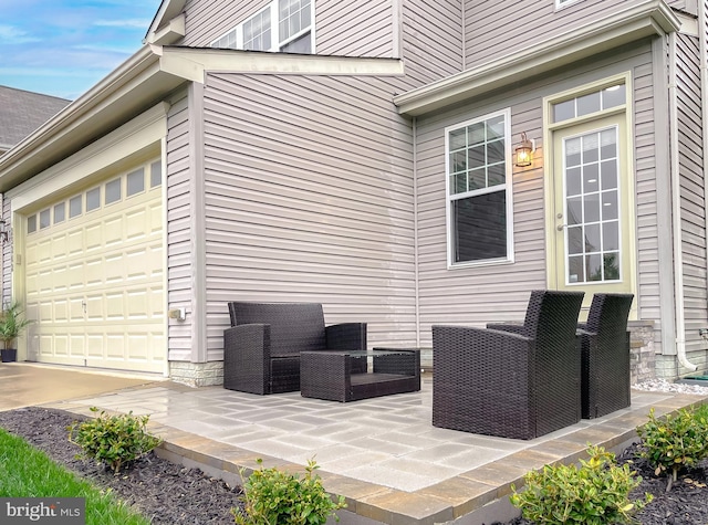 view of side of home featuring a patio area, outdoor lounge area, a garage, and driveway