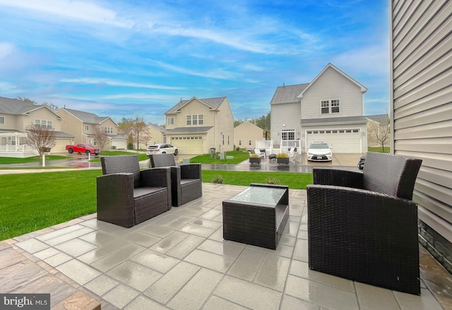 view of patio / terrace featuring a residential view, an attached garage, and an outdoor hangout area