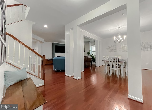 entrance foyer with wood finished floors, an inviting chandelier, baseboards, and stairway