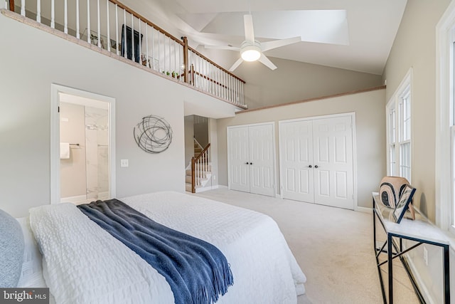 3568 S George Mason Dr Unit 12, Alexandria, VA 22302 - bedroom with connected bathroom, light colored carpet, two closets, high vaulted ceiling, and ceiling fan