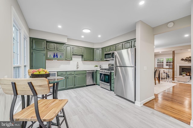 3568 S George Mason Dr Unit 12, Alexandria, VA 22302 - kitchen featuring light wood-style flooring, appliances with stainless steel finishes, green cabinetry, and a sink