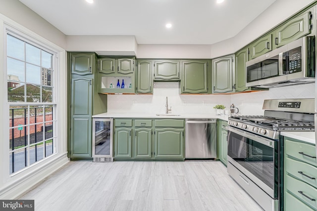 3568 S George Mason Dr Unit 12, Alexandria, VA 22302 - kitchen featuring green cabinetry, beverage cooler, appliances with stainless steel finishes, and light countertops