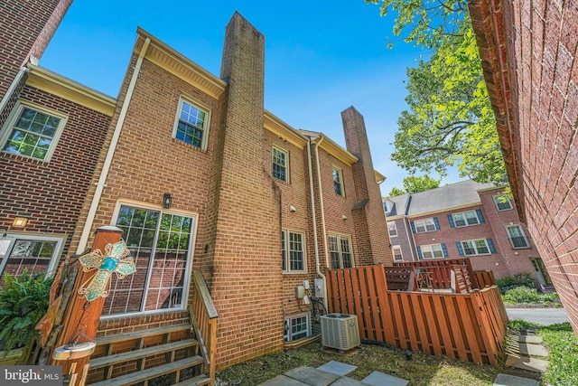3568 S George Mason Dr Unit 12, Alexandria, VA 22302 - rear view of property with brick siding, entry steps, central AC, and a chimney