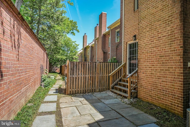 3568 S George Mason Dr Unit 12, Alexandria, VA 22302 - view of home's exterior featuring brick siding, fence, and entry steps