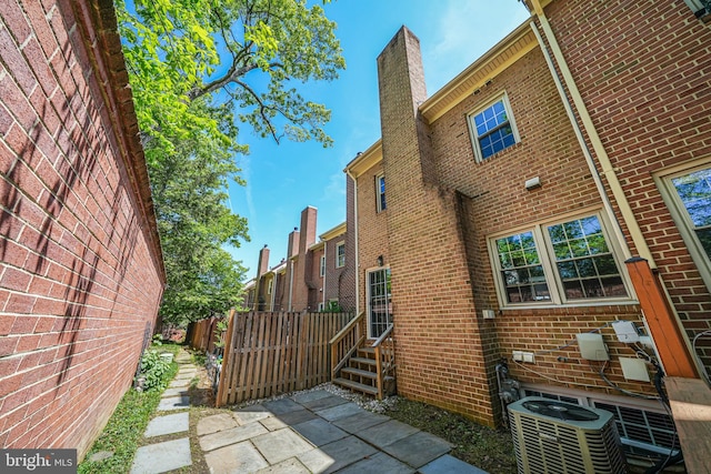 3568 S George Mason Dr Unit 12, Alexandria, VA 22302 - view of side of home with brick siding, a chimney, and fence