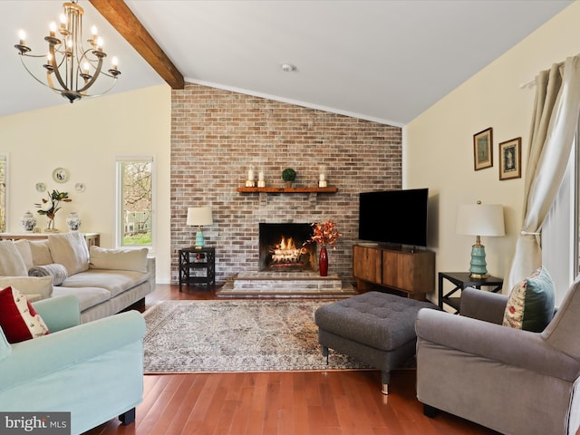 living area with wood finished floors, a notable chandelier, lofted ceiling with beams, and a fireplace