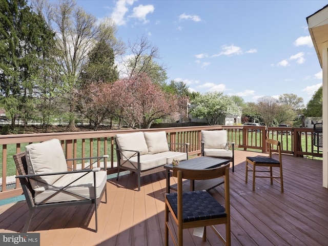 wooden terrace featuring an outdoor hangout area and fence