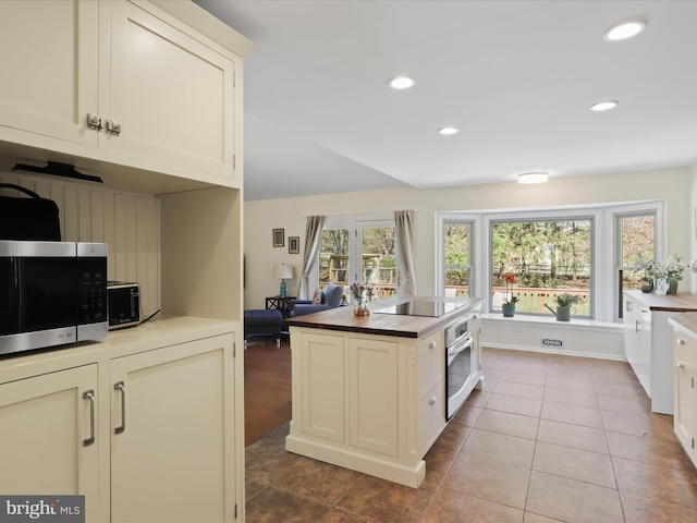 kitchen featuring stainless steel appliances, recessed lighting, butcher block counters, and tile patterned flooring