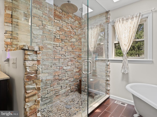 bathroom featuring a freestanding tub, visible vents, wood tiled floor, a stall shower, and baseboards