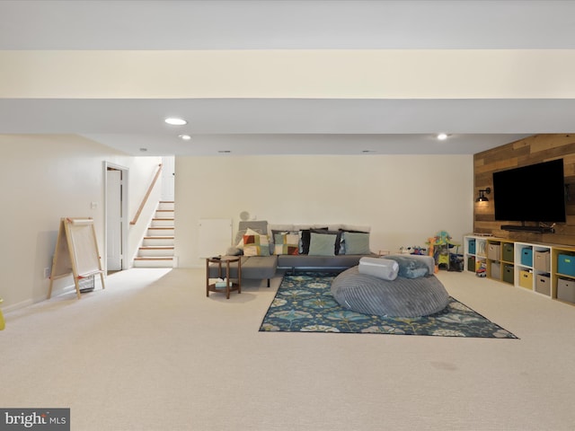 living area with wooden walls, stairs, recessed lighting, and carpet floors