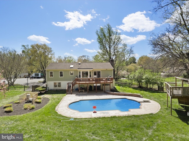 back of property with a yard, stairway, a wooden deck, and fence