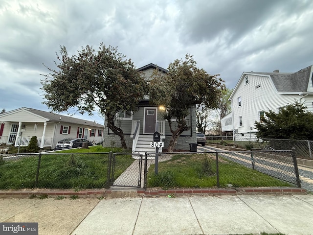 view of front of home featuring a gate, a front lawn, and a fenced front yard