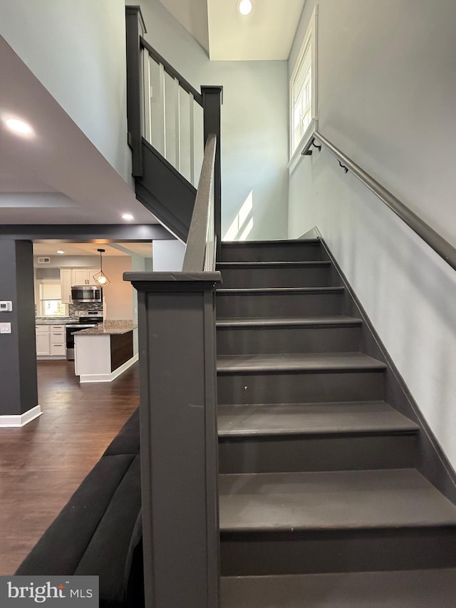 stairs featuring recessed lighting, wood finished floors, and baseboards