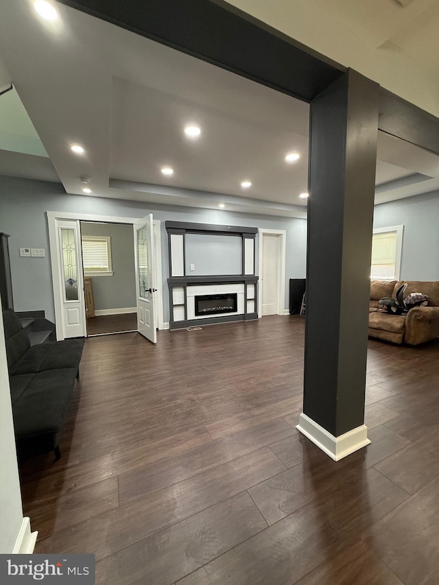 living room with stairway, a glass covered fireplace, dark wood finished floors, baseboards, and recessed lighting