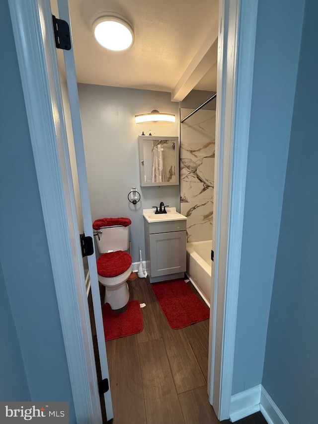 full bath with wood finished floors, vanity, shower / bath combination, baseboards, and toilet