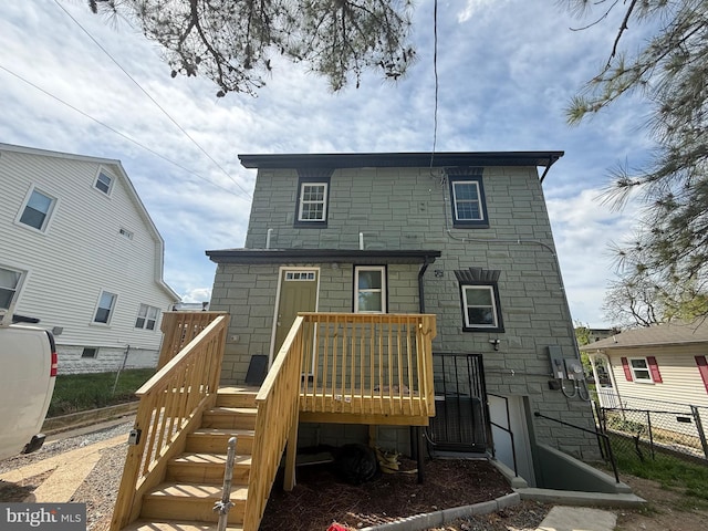 rear view of house with stairs, fence, and a deck