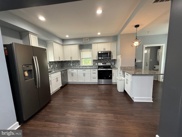 kitchen featuring decorative backsplash, stone counters, dark wood finished floors, a peninsula, and appliances with stainless steel finishes
