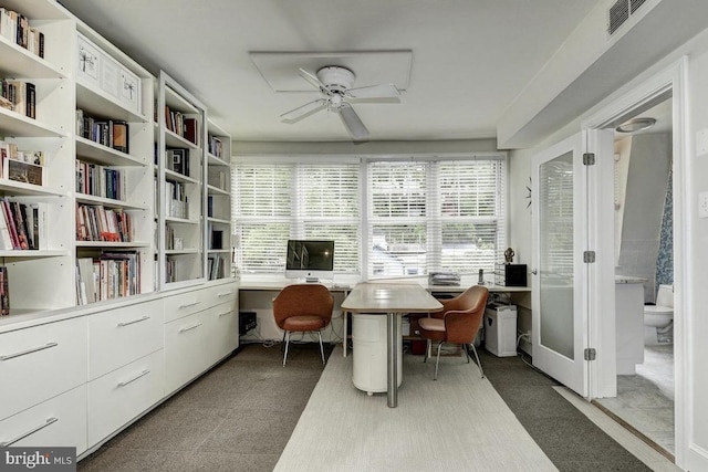 home office with a ceiling fan and built in desk