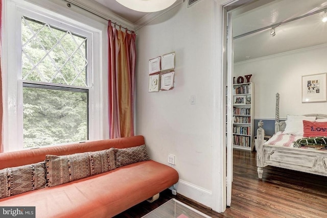 sitting room with ornamental molding, baseboards, wood finished floors, and rail lighting