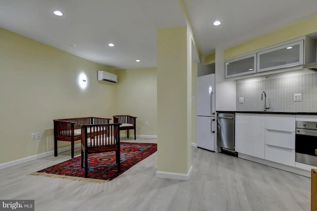 kitchen featuring appliances with stainless steel finishes, a wall mounted AC, decorative backsplash, glass insert cabinets, and recessed lighting