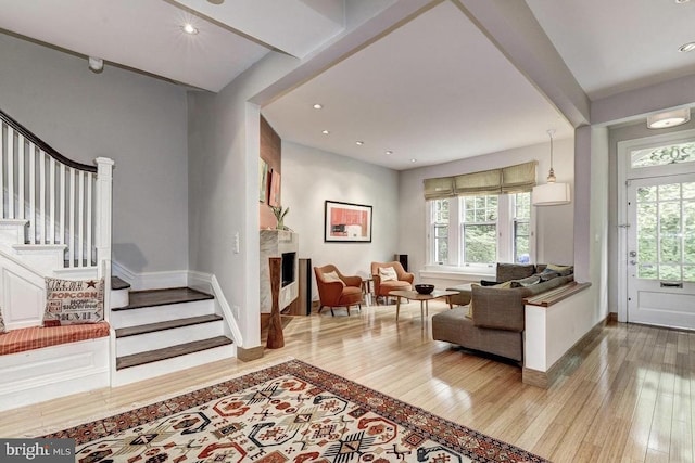 living area featuring wood-type flooring, stairs, baseboards, and recessed lighting