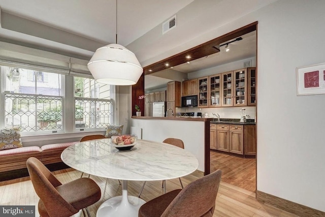 dining room featuring light wood-style flooring and baseboards